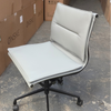 White office chair with black wheels in a warehouse setting 
