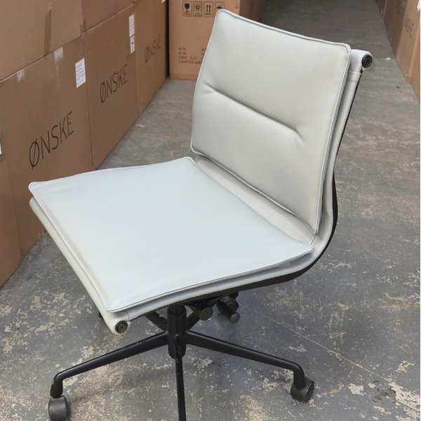 White office chair with black wheels in a warehouse setting 