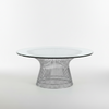 A coffee table with a steel lattice base and a circular tempered glass top.